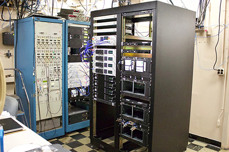 The completed (black rack) KPGO backend standing next to the (blue rack) Westford broadband backend. Shown from top to bottom are (left) the frequency and time reference distribution amplifiers, radio-frequency distributor, up-down converters, digitizers, server, and (right) two Mark6 recorders.